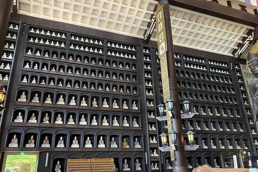 A large wall of statues in a temple. 3