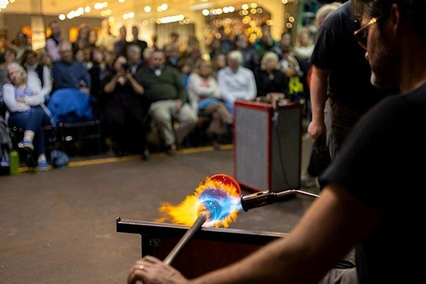 A person performing a fire-breathing act in front of an audience. 2