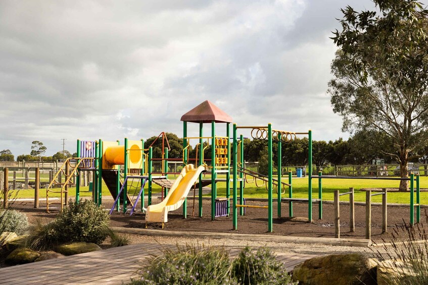 A playground with a slide, climbing structures, and a covered play area. 3