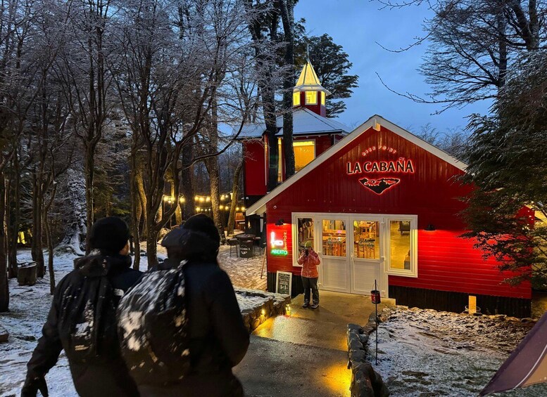 A red building with a sign reading 'LA CABANA' in a snowy forest. 5