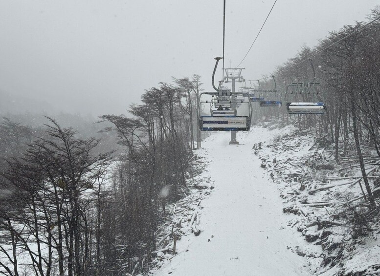 A snow-covered ski lift in a forested area. 3