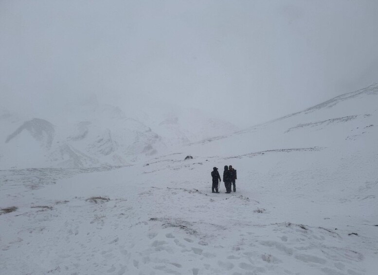 Two people hiking on a snowy mountain trail. 2