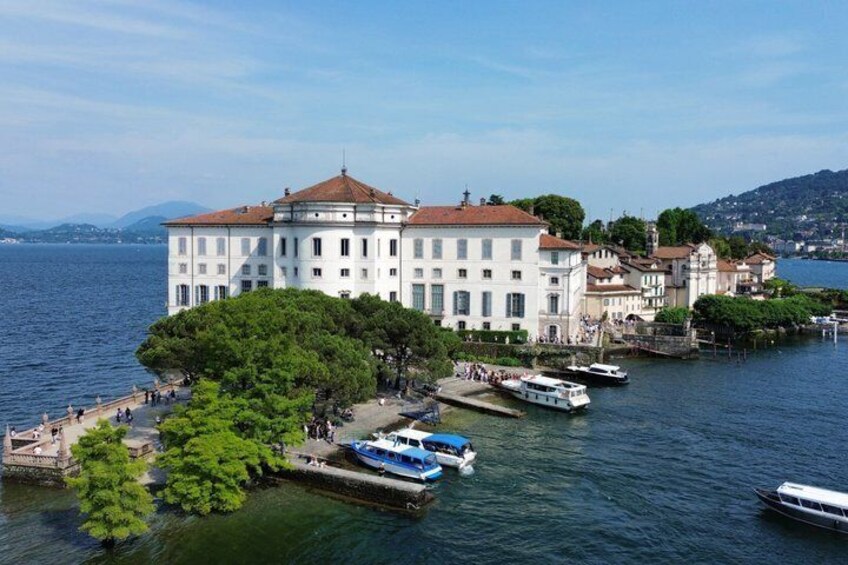 A waterfront building with boats docked, surrounded by trees and a clear sky. 5