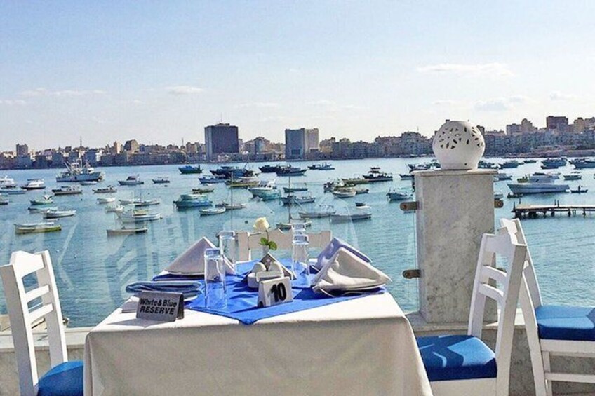 A table set for two with a cityscape and marina in the background. 4