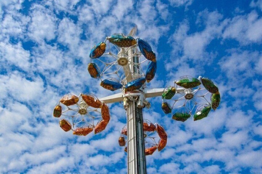 A Ferris wheel with colorful gondolas against a blue sky with clouds. 5