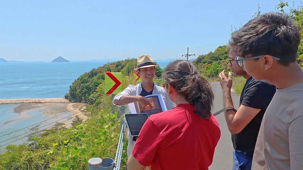 A group of people on a coastal trail with a view of the sea and a distant island. 5