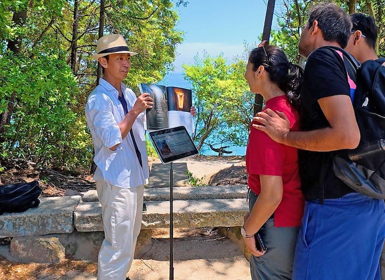 A guide leading a group of tourists through a natural area with a rocky path and trees. 1