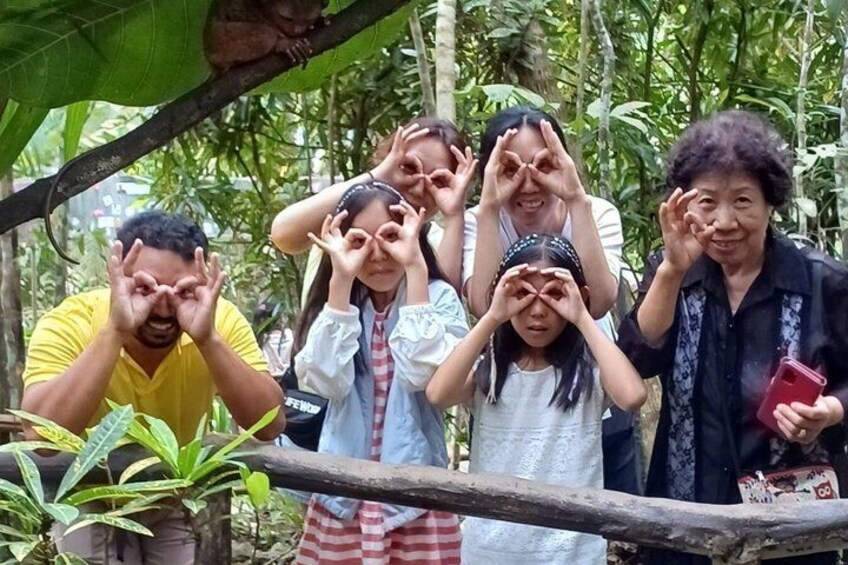 A group of people outdoors, some making hand gestures. 1