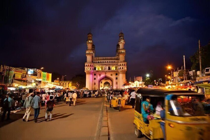 A busy street with a prominent mosque and a large archway. 2