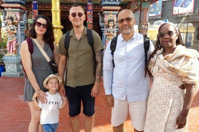 A family of four at a temple with intricate architecture and statues. 5