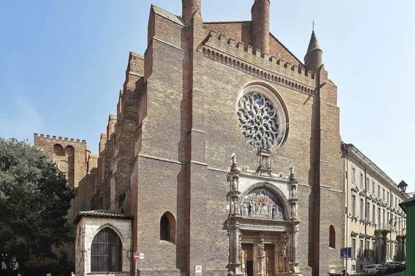 A historic church with a large circular window, a tall bell tower, and a detailed facade. 4