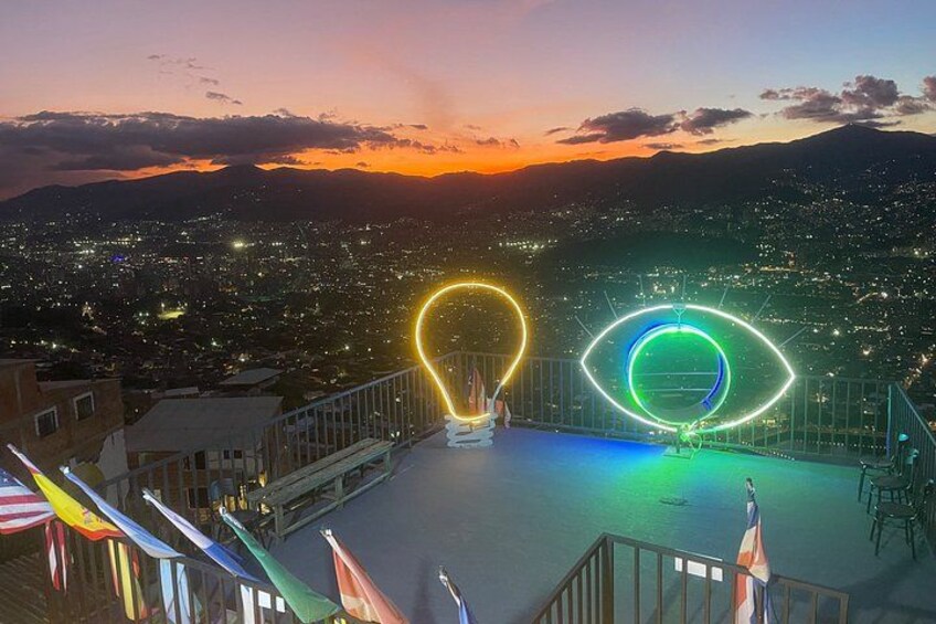 A cityscape at dusk with illuminated neon rings on a rooftop. 4