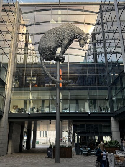 A modern building with a glass facade and a large metal sculpture of a bear. 3