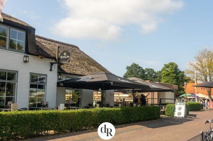A building with a thatched roof, a covered outdoor seating area, and a sign that reads 'Elder's Inn.' 3