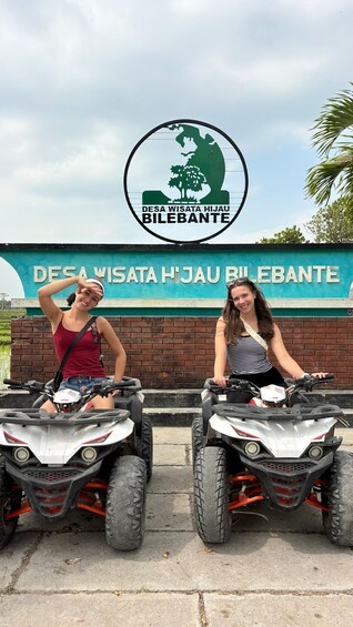 Two people on ATVs in front of a sign that reads 'DESA WISATA HIJAU BILEBANTE'. 2