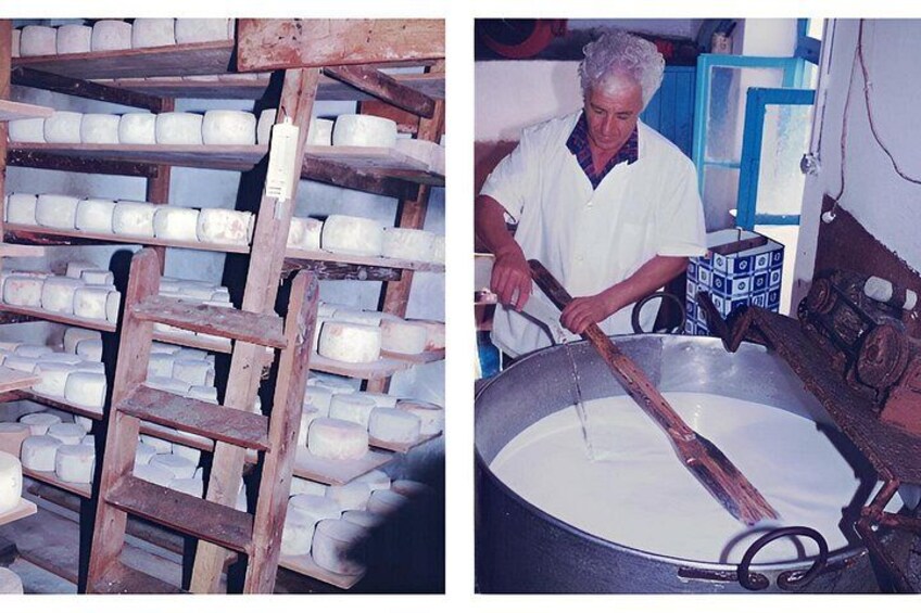 A person stirring a large pot of milk in a kitchen with shelves of milk cartons in the background. 5