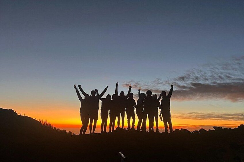 A group of people silhouetted against a sunset sky. 2