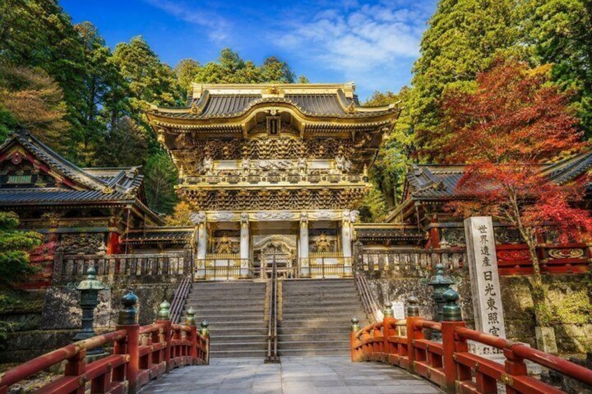 A traditional Japanese temple with a red torii gate, a stone staircase, and a sign with Japanese characters. 3