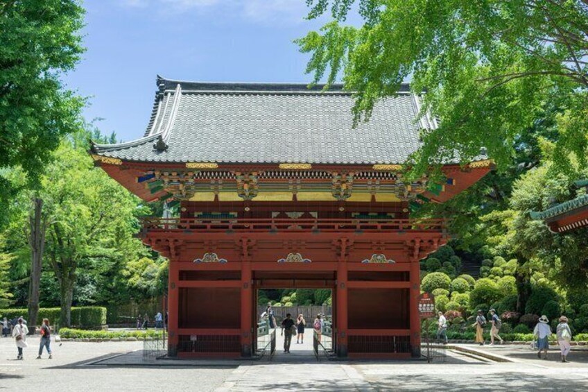 A traditional Japanese gate with intricate roof details and vibrant red pillars. 2