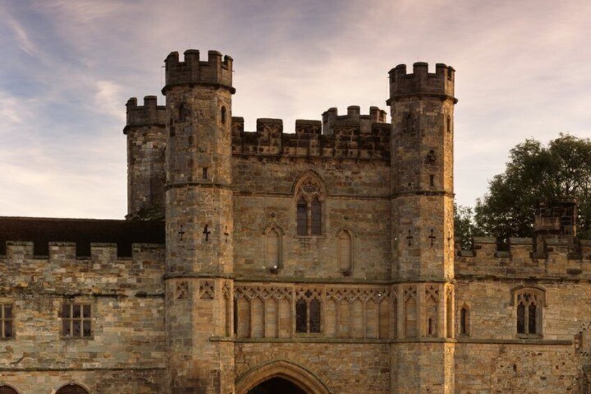 A historic stone castle with two prominent towers, arched windows, and a large entrance. 1