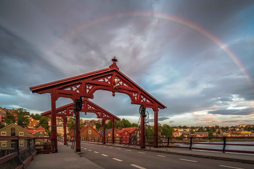 A red metal structure with intricate designs, a chain mechanism, and a rainbow in the sky. 5