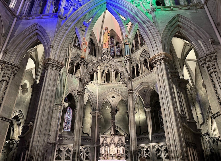 A Gothic cathedral interior with pointed arches, stained glass windows, and statues. 2