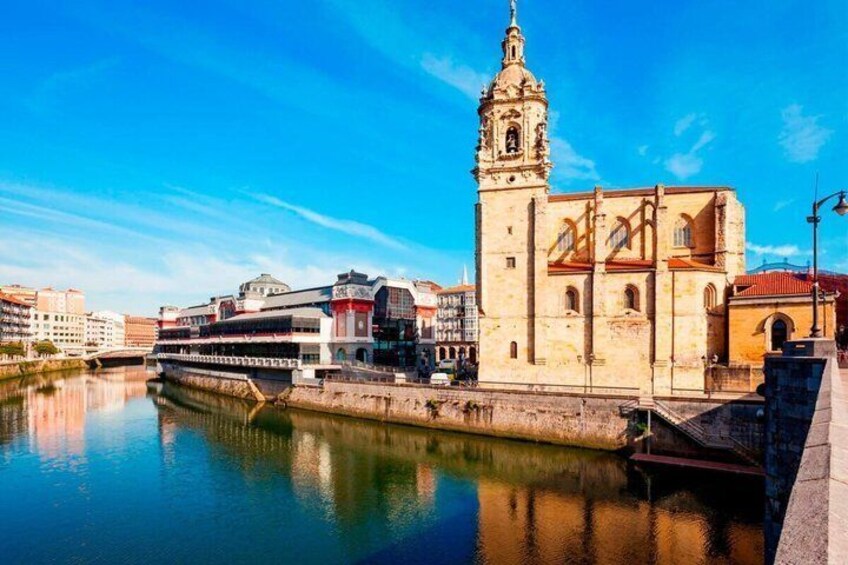 A river with a historic building featuring a bell tower, a modern bridge, and a reflection of the sky. 3