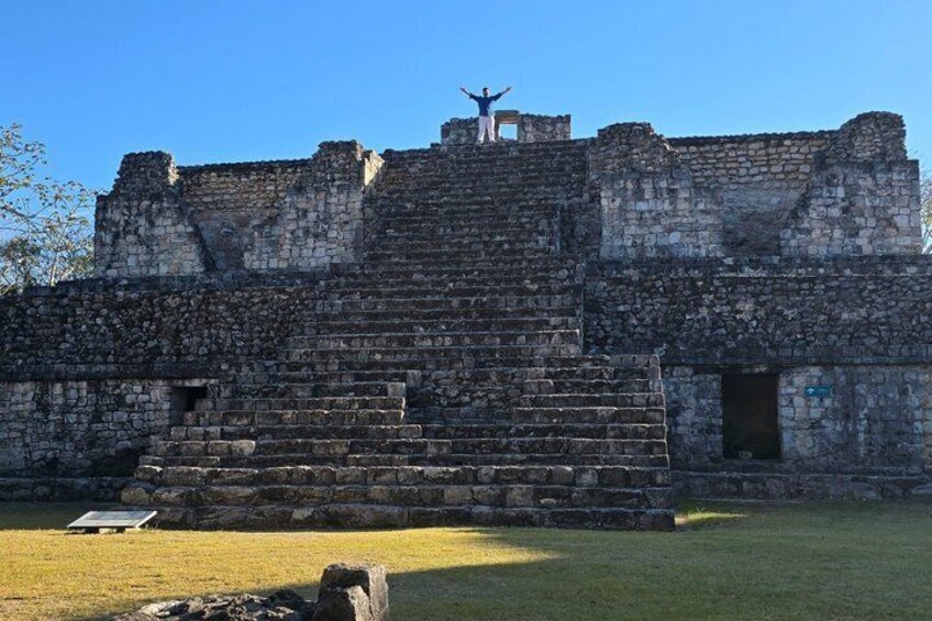 A stone pyramid structure with a person standing on top. 1