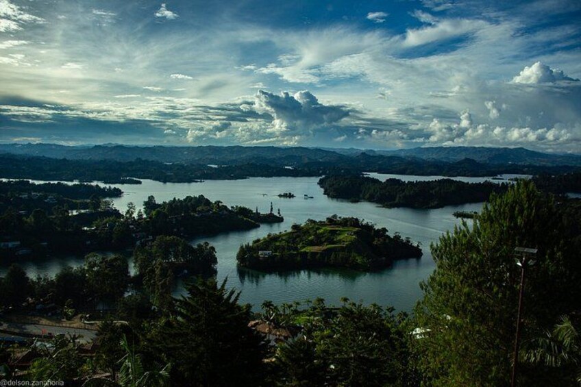 A lake surrounded by dense forest and hills. 2