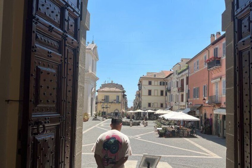 A street view with a man walking, buildings, and outdoor seating. 3