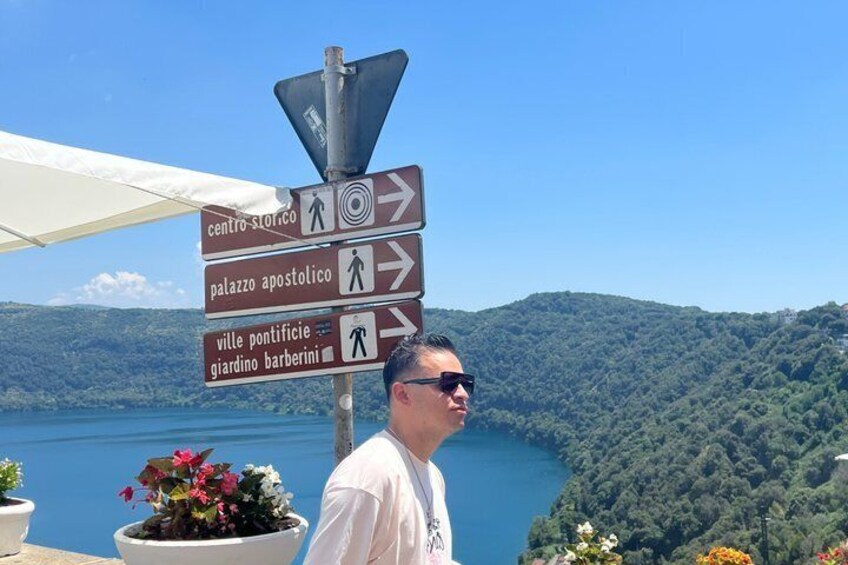 A man standing next to a directional signpost with multiple arrows pointing to various destinations. 1
