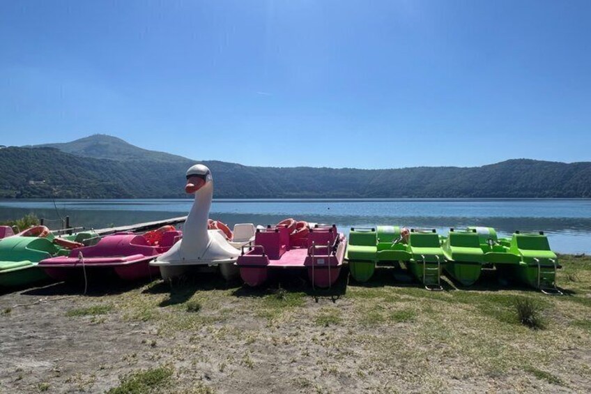 A lake with boats and a swan statue. 5