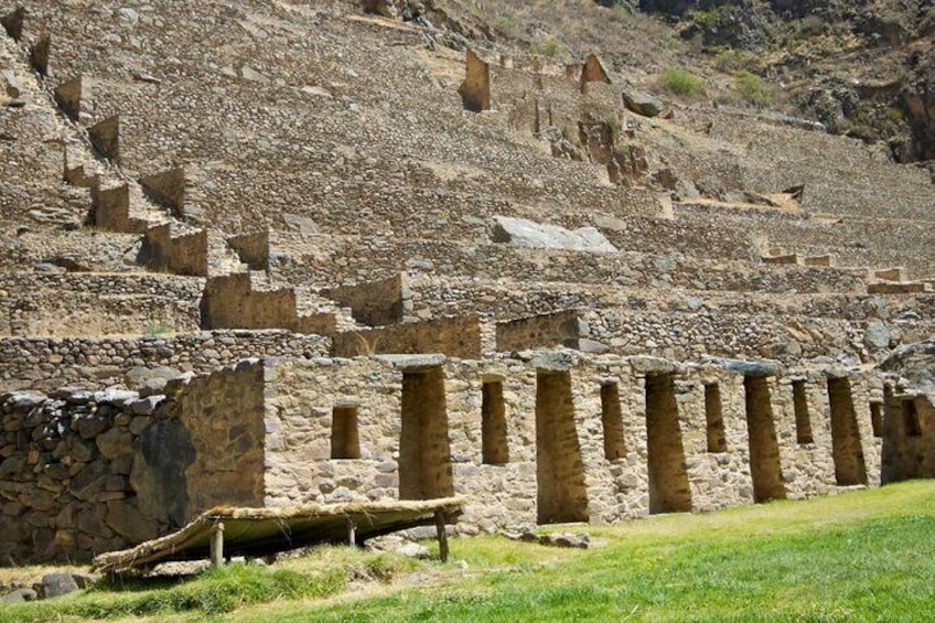 Ancient stone ruins with rectangular doorways and a grassy foreground. 4