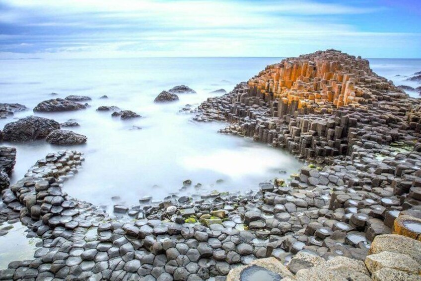 A rocky coastline with a prominent hexagonal basalt formation. 3
