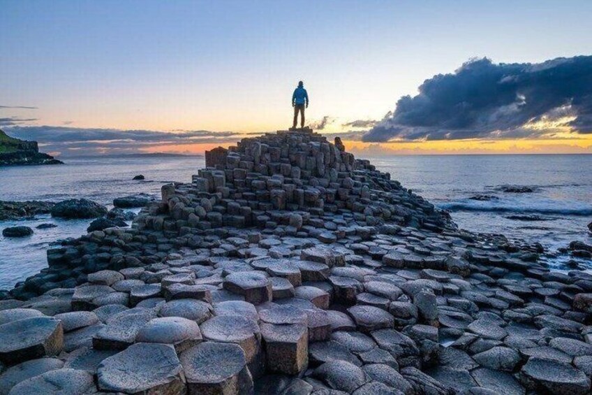 A hexagonal stone structure by the sea at sunset. 2