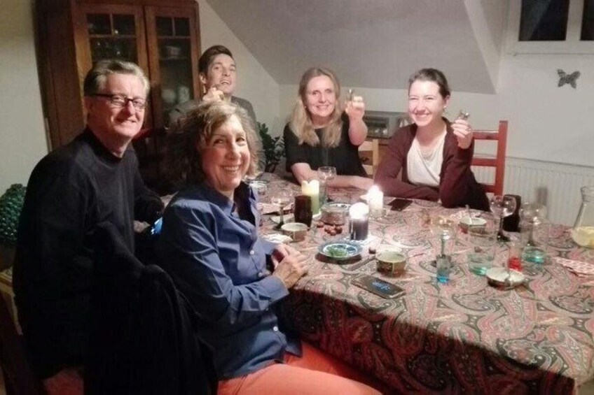 A group of people sitting around a table with food and drinks. 5