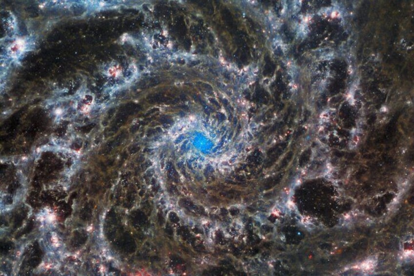 A spiral galaxy with bright star clusters and a central blue core. 4