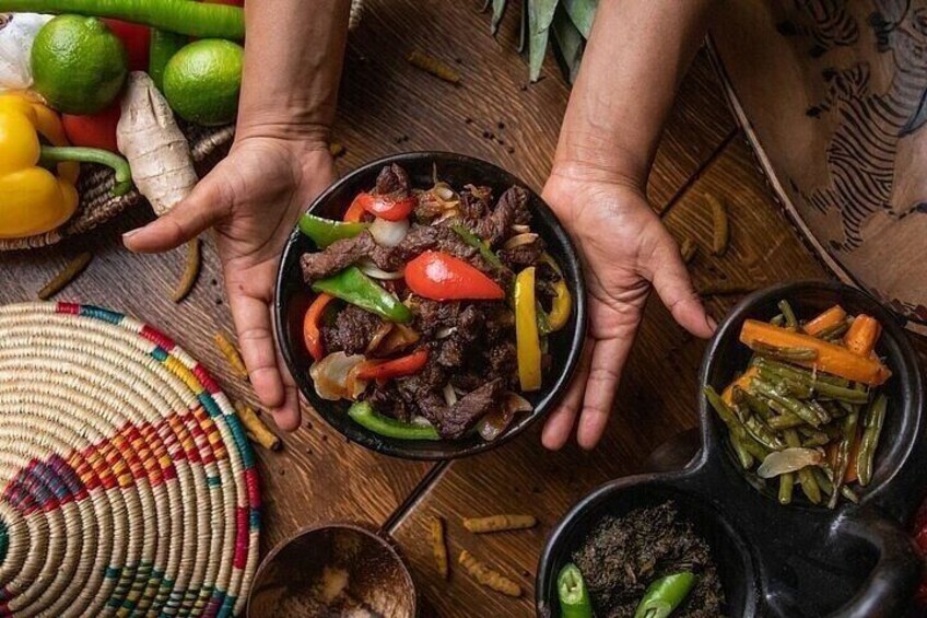 A person holding a bowl of beef stir-fry with vegetables. 3