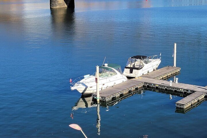 A boat docked at a pier with calm water and a paddle in the foreground. 3