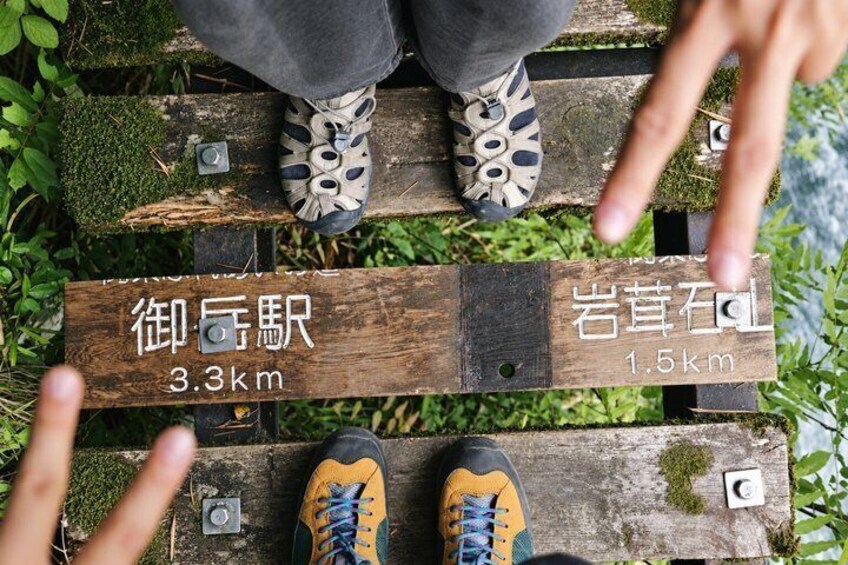 A wooden board with distance markers and text in a foreign language. 2