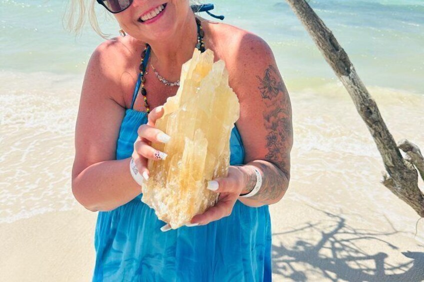 A person holding a large piece of coral on a beach. 1