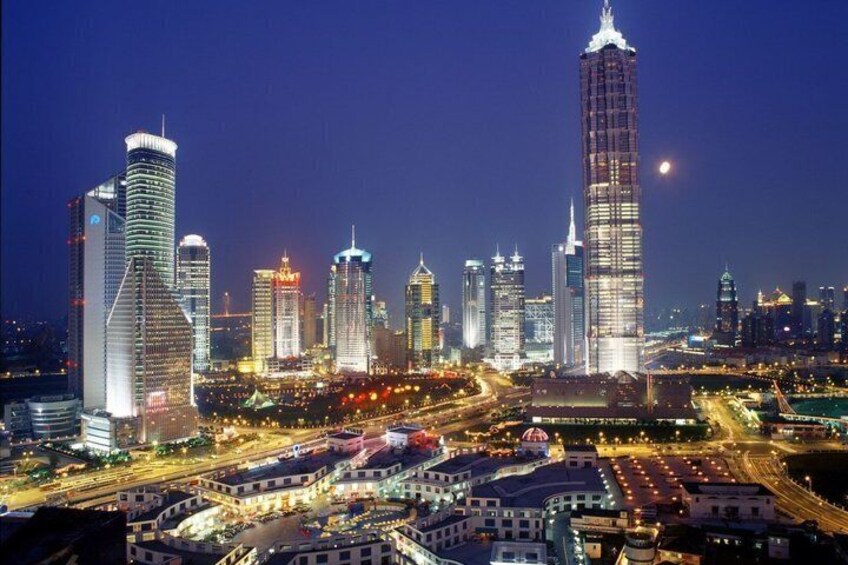 A cityscape at night with illuminated skyscrapers and busy streets. 2