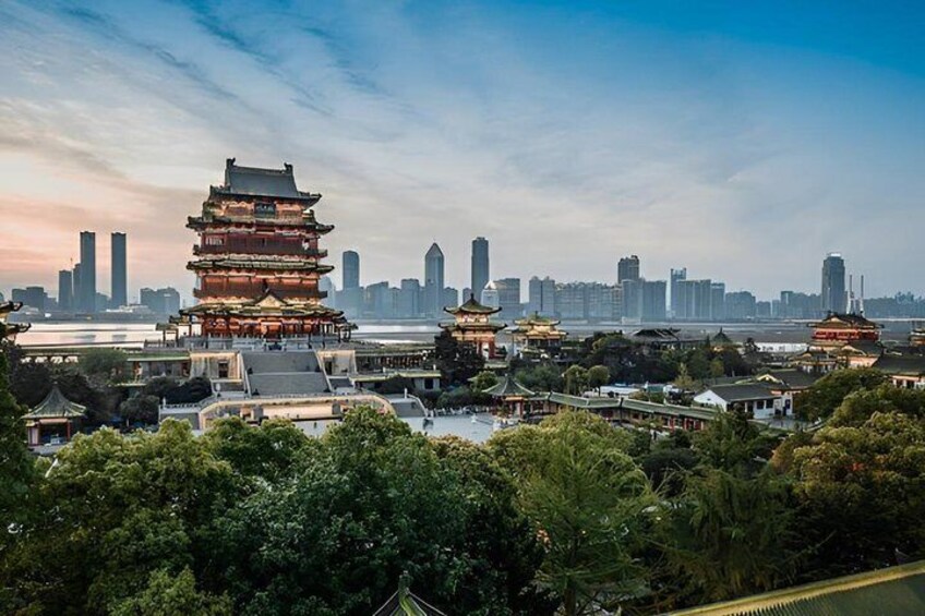 A traditional pagoda with multiple tiers, surrounded by lush greenery and modern skyscrapers in the background. 4