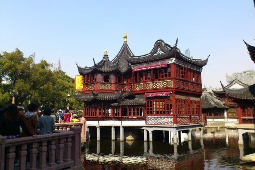 A traditional Chinese pavilion with ornate architecture, situated on stilts over water. 3