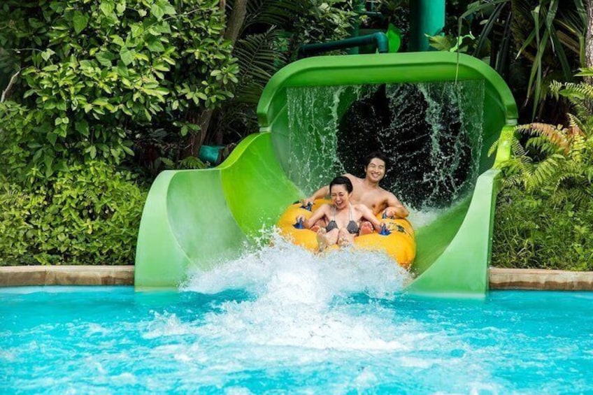 A water slide with two people in yellow inflatable tubes. 3