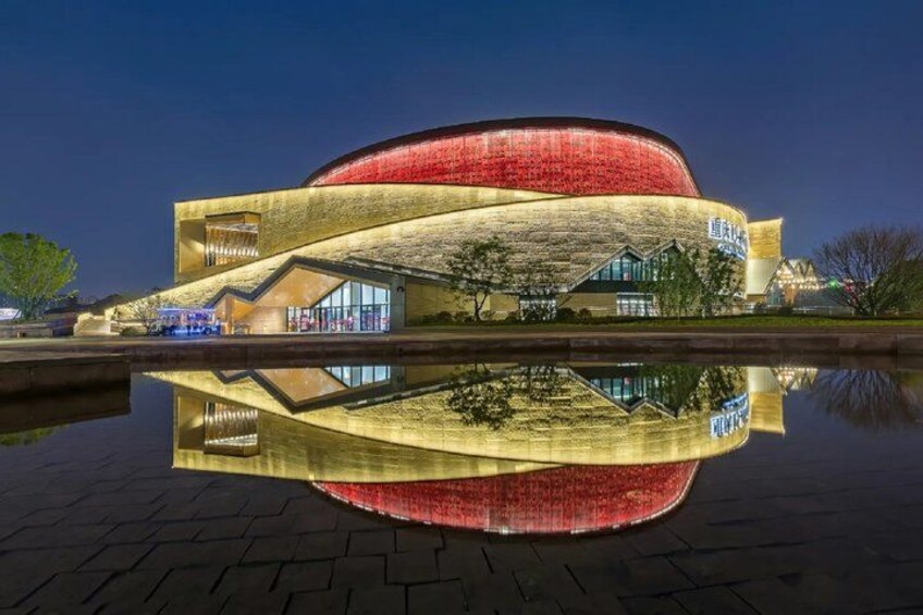 A modern building with a curved facade and a reflection in the water. 2