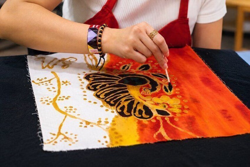 A person painting a colorful design on fabric. 1
