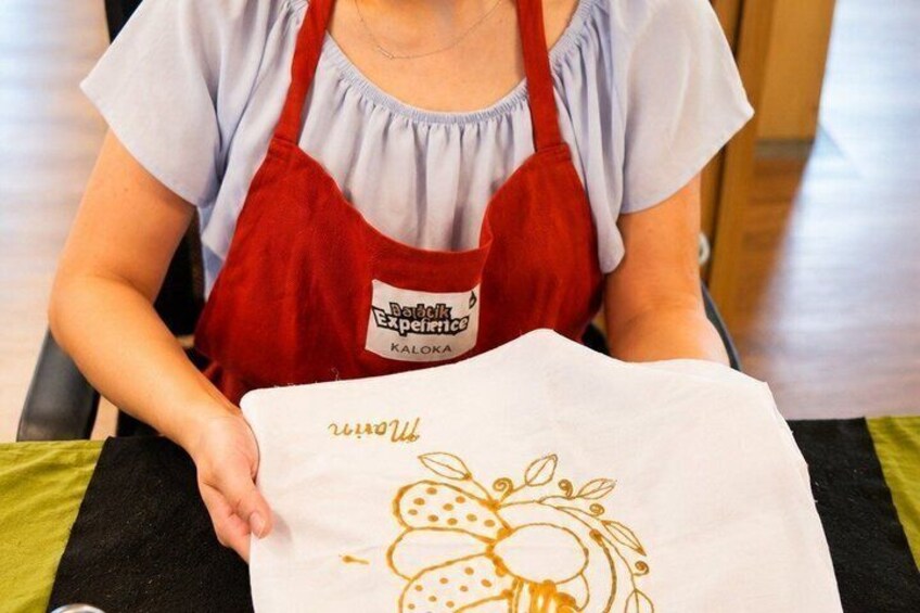 A person holding a white paper with a drawing of fruits and leaves. 3