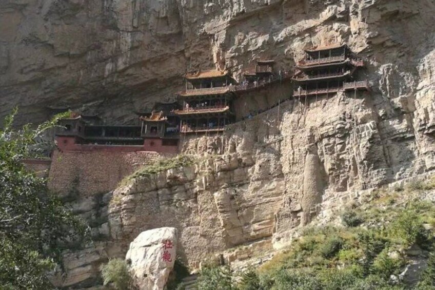 A cliffside monastery with multiple levels of buildings. 5