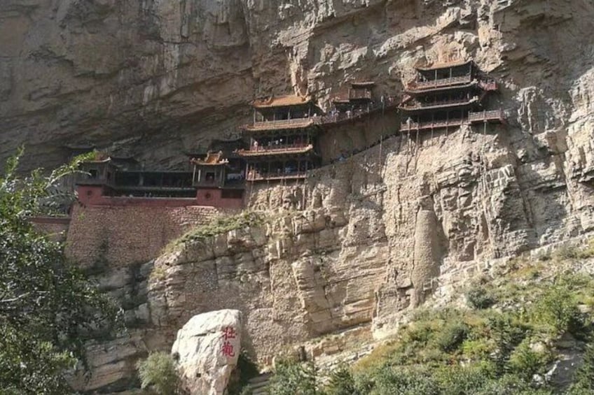 A cliffside with traditional multi-tiered buildings. 5